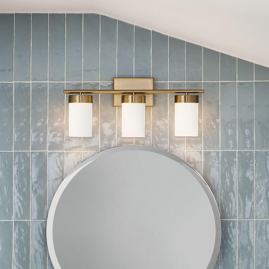 KICHLER 55112BNB Ciona 24" 3 Light Vanity Lighte With Round Ribbed Glass Brushed Natural Brass