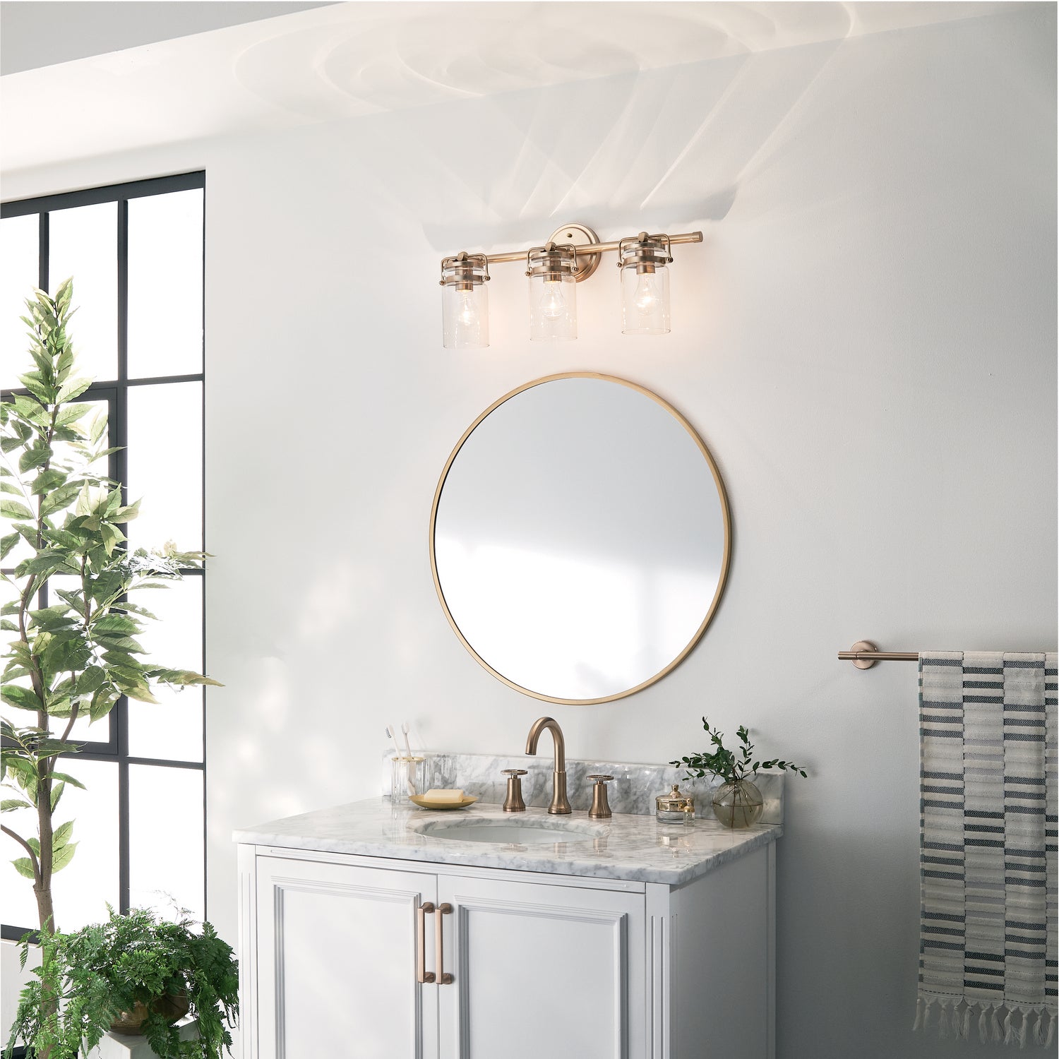 KICHLER 45689CPZ Brinley 24" 3 Light Vanity Light With Clear Glass In Champagne Bronze
