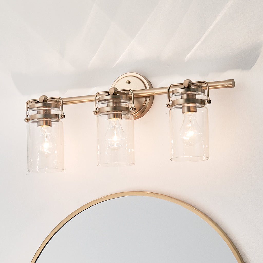 KICHLER 45689CPZ Brinley 24" 3 Light Vanity Light With Clear Glass In Champagne Bronze