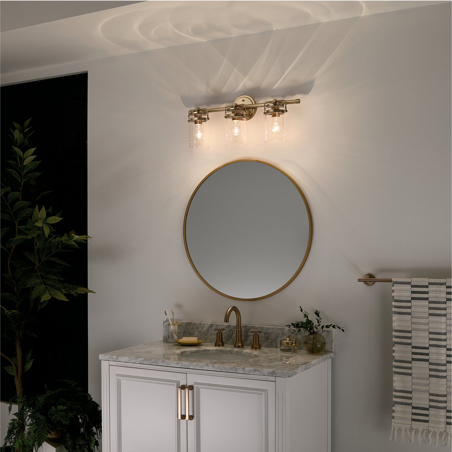 KICHLER 45689CPZ Brinley 24" 3 Light Vanity Light With Clear Glass In Champagne Bronze